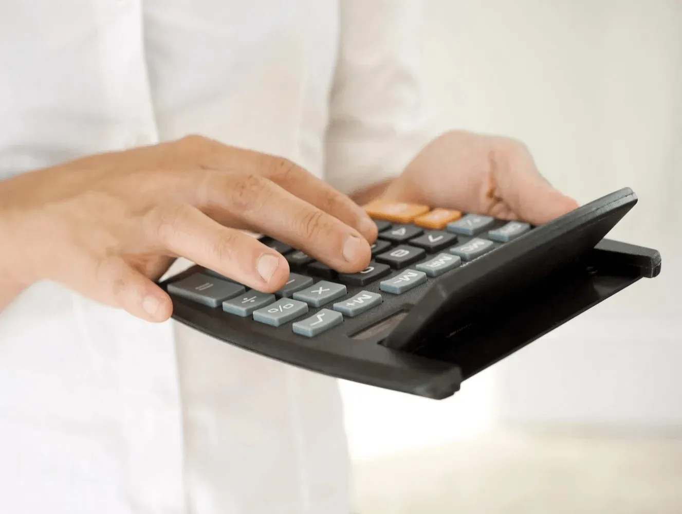 Un conseiller utilisant une calculatrice pour établir le devis détaillé de prestations funèbres
