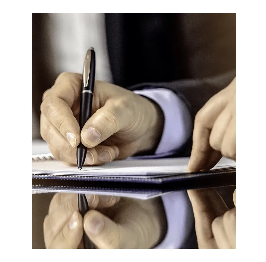 Mains d'une personne remplissant des documents administratifs pour l'accompagnement des familles.