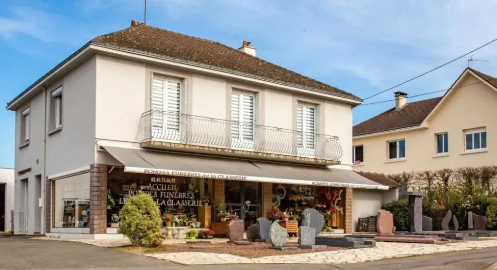 Façade de l'agence Pompes Funèbres de la Classerie avec exposition de stèles.